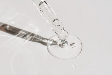 A drop of cosmetic oil falls from the pipette