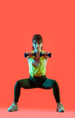 Poster - Sporty young woman training with dumbbells on color background