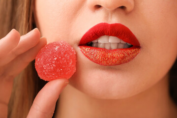 Wall Mural - Beautiful young woman with sweet candy, closeup