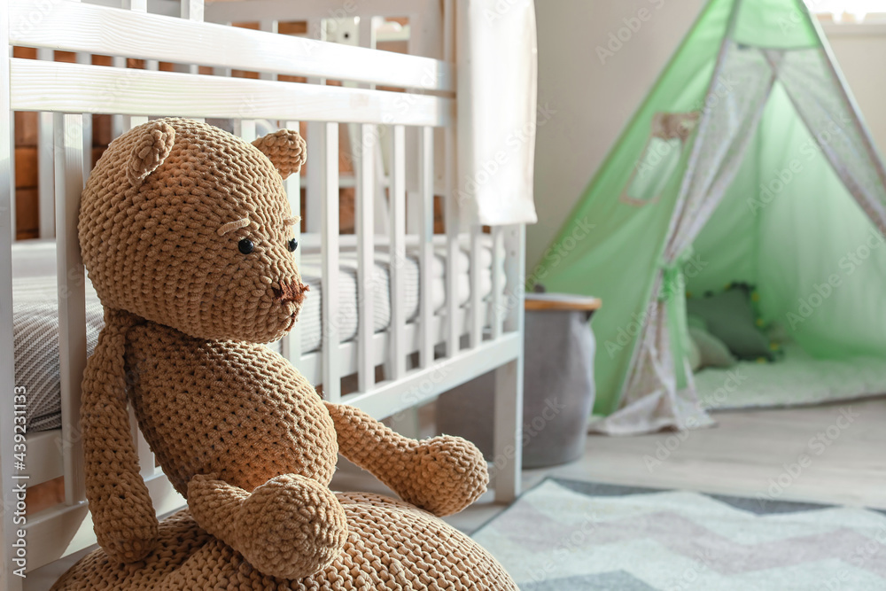 Teddy bear on floor in modern children's room, closeup