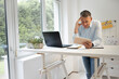 © epiximages - business man with blue shirt is standing behind high standing table and is working with his tablet
