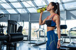 © nazarovsergey - Sporty woman drinking water during workout at gym