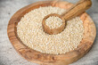 White quinoa seeds in wooden bowl