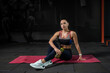 © nazarovsergey - Athletic young woman sitting on mat in modern gym
