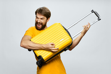 cheerful man tourist with a suitcase in the hands of the airport luggage