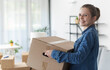 © StockPhotoPro - Happy woman carrying boxes in her new home