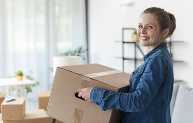 Wall Mural - Happy woman carrying boxes in her new home