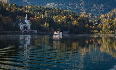 Fototapete - Amazing autumn scenery of mountain lake at sunny day. Pleasure boat on a Grundlsee lake. Austria. Amazing nature landscape. Picture of alps calm lake. concept of an ideal resting place