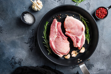 Wall Mural - Pork steaks, fillets for grilling, baking  in frying pan black skillet with herbs, spices  top view flatlay