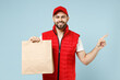 © ViDi Studio - Delivery guy employee man in red cap white T-shirt vest uniform work as dealer courier service hold brown clear blank craft paper takeaway bag mock up isolated on pastel blue color background studio.