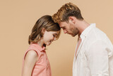 Fototapeta  - Side view young cool parent man have fun with cute child teen girl in casual pastel clothes. Daddy little kid daughter stand head to head isolated on beige background Father's Day Love family concept