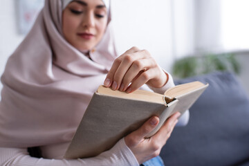 Wall Mural - blurred muslim woman reading novel at home