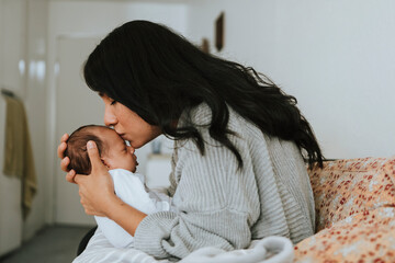 Wall Mural - loving mother kissing her infant baby