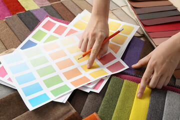 Sticker - Woman choosing among colorful fabric samples, closeup