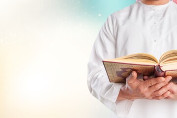 Poster - Man Holding and reading quran book. Islamic Background.