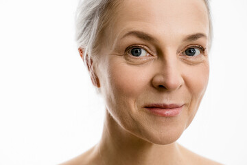 Wall Mural - Woman with perfect soft face skin looking to the camera and smiling while posing