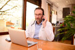 © W PRODUCTION - handsome male doctor giving a remote medical consultation over internet computer telemedecine diagnostic from home