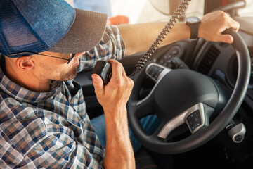 Wall Mural - Caucasian Trucker Providing Conversation Using CB Radio Inside His Truck