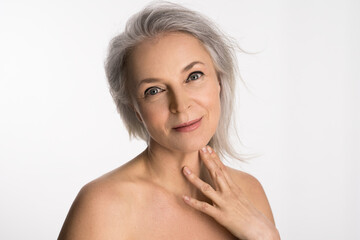 Wall Mural - Aged woman with healthy glowing skin and happy smile touching her neck