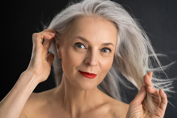 Wall Mural - Adult senior woman touching her perfect grey hair