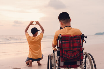 Wall Mural - Asian special child on wheelchair on the beach with parents in family holiday to travel, Take photo the camera nature around the sea beach, Life in the education age, Happy disabled kid concept.