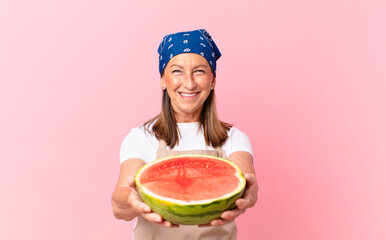 middle age pretty woman with an apron and holding a watermelon