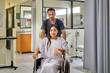© PER Images/Stocksy - Healthcare: patient in a wheelchair by nurse assistant