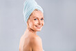 © denis_vermenko - Portrait of smiling senior woman feeling soft skin with hand after spa bath. Mature woman draped in towel looking at camera. Lady in bathrobe after shower isolated over white background.