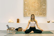 © VISUALSPECTRUM/Stocksy - Female Yoga Instructor Teaching Online Meditation Class During Lockdown