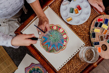 Top View Of Little Girl Painting A Colorful Mandala At Home