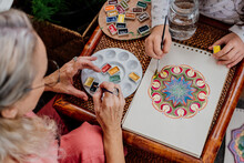 Little Kid Painting Mandalas With Her Grandmother At Bedroom 