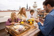 © VICTOR TORRES/Stocksy - Happy family having breakfast on terrace