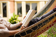 © Malquerida Studio/Stocksy - Young woman lying in a hammock reading a book