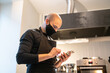 © Hernandez & Sorokina/Stocksy - Chef Holding Mobile Phone At Kitchen
