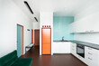 © Luciano Spinelli/Stocksy - Minimalist living room / kitchen with blue, green and orange elements