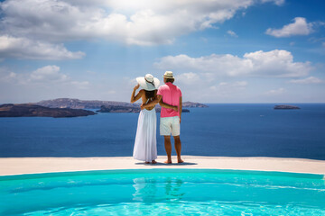 Wall Mural - Hugging couple on vacation time enjoys the summer sunset behind the mediterranean sea by the swimming pool 