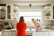 © Jennifer Bogle/Stocksy - Girl crouches on kitchen counter with mother