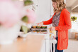 © Jennifer Bogle/Stocksy - Woman arranges fresh baked muffins