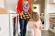 © Jennifer Bogle/Stocksy - Littel girl examines muffins fresh from oven