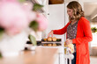 © Jennifer Bogle/Stocksy - Woman sets muffins on cooking rack