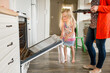 © Jennifer Bogle/Stocksy - Girl opens oven for her mother