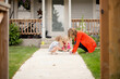 © Jennifer Bogle/Stocksy - Mother and daughters draw with chalk on sidewalk