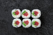 Sake maki Japanese roll with Tuna, cucumber and avocado on stone. Maguro sushi-roll, top view