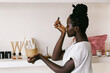 © VISUALSPECTRUM/Stocksy - Self-Care - Black Woman Smelling Essential Oil on Wrist