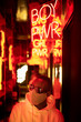 © VICTOR TORRES/Stocksy - Stylish black man under neon signboard in city