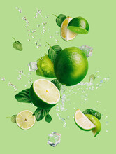 Slices Of Fresh And Ripe Lime With Ice Cubes, Splashing Water And Mint Leaves Thrown In The Air, Flying And Levitating On A Bright Green Background. Creative Food Concept. Summer Citrus Fruit.