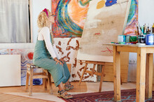 Senior Woman Sitting In Her Art Studio At Home