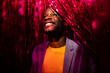© VICTOR TORRES/Stocksy - A cheerful black man in party with red serpentines