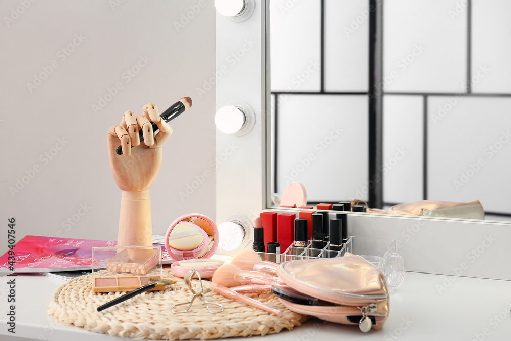 Set of makeup brushes and cosmetics on dressing table