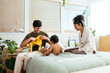 © BONNINSTUDIO/Stocksy - Happy parents dressing up kid in morning